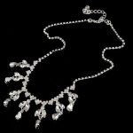  Halskette verziert mit Anhängern und Kristallen, silberfarben