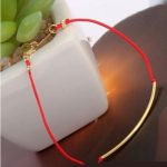 Rotes Kordelarmband, funkelndes Gold