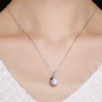 Silberne Halskette mit Perlenanhänger, schwarz und weiß