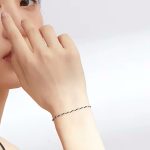 Ezüst karkötő zsinórral, fekete